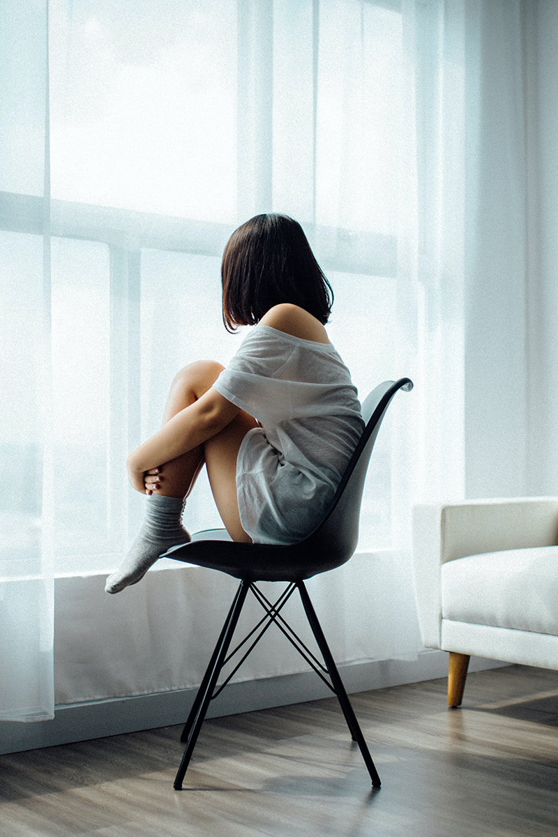 Girl on her own, gazing out of the window